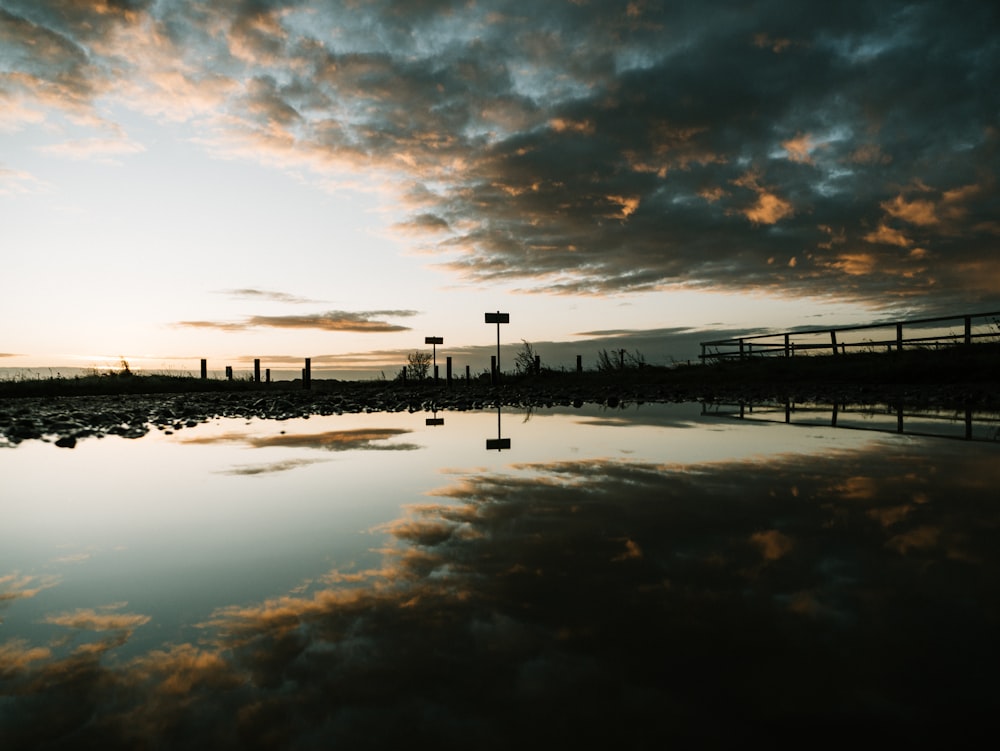 body of water under blue and orange sky during daytime