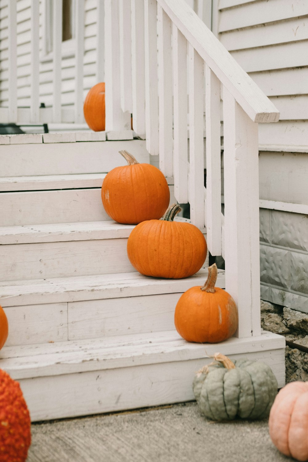 calabazas naranjas en escaleras de madera blanca