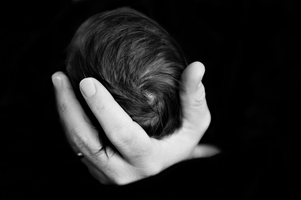 grayscale photography of person holding baby