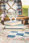 A serene outdoor scene with a picnic blanket laid out, featuring Jamie Barnes’ books and a watercolor palette.