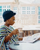 woman holding coffee cup and newspaper