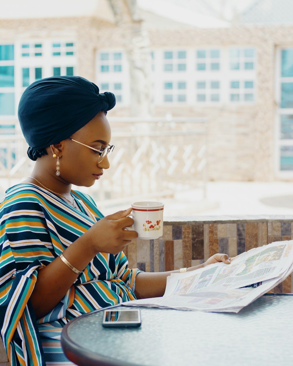 woman holding coffee cup and newspaper