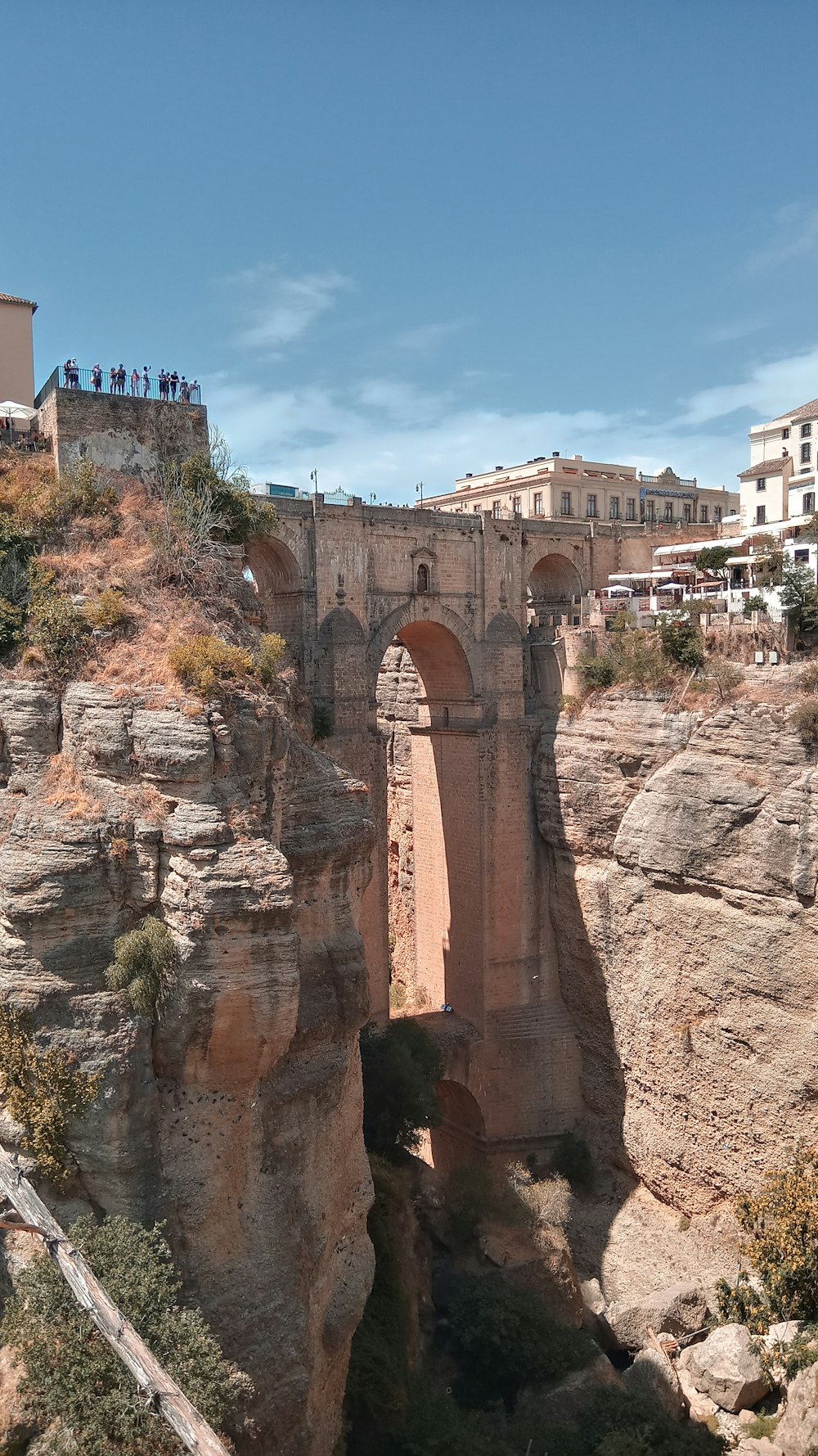 a bridge over a canyon with people standing on top of it