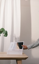 Stack of church magazines and articles laid out on a wooden table.