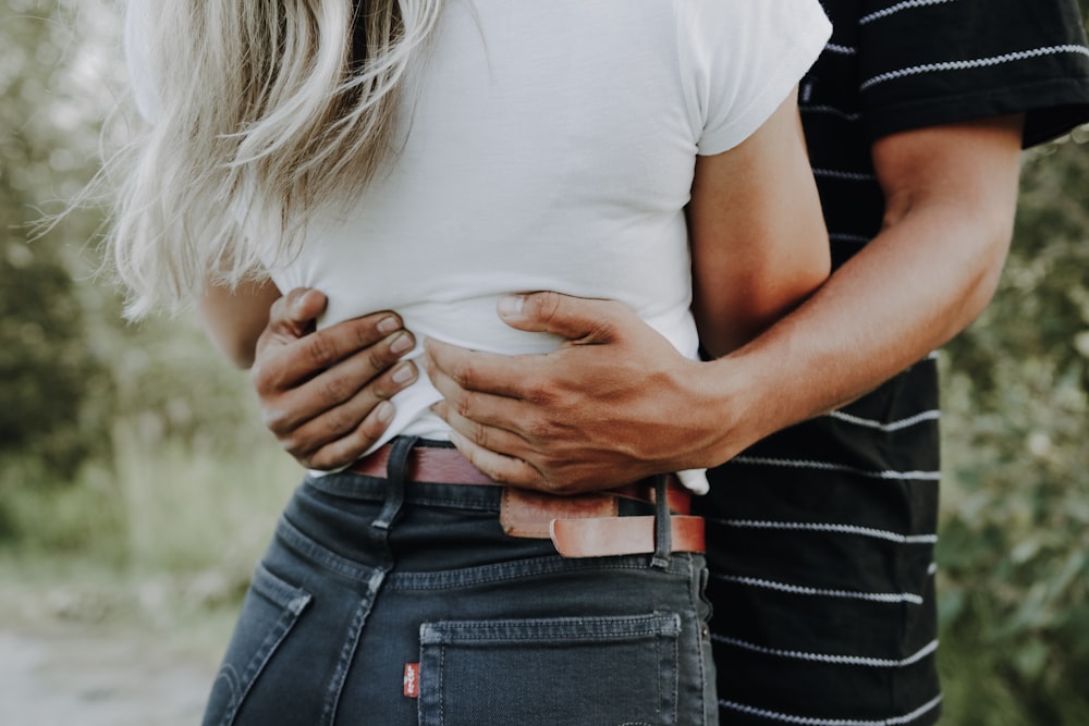 man hugging woman near trees