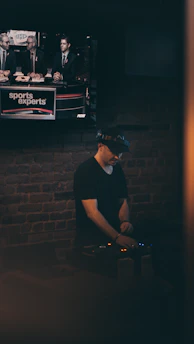 A focused sports analyst reviewing game footage on multiple screens in a dimly lit room.