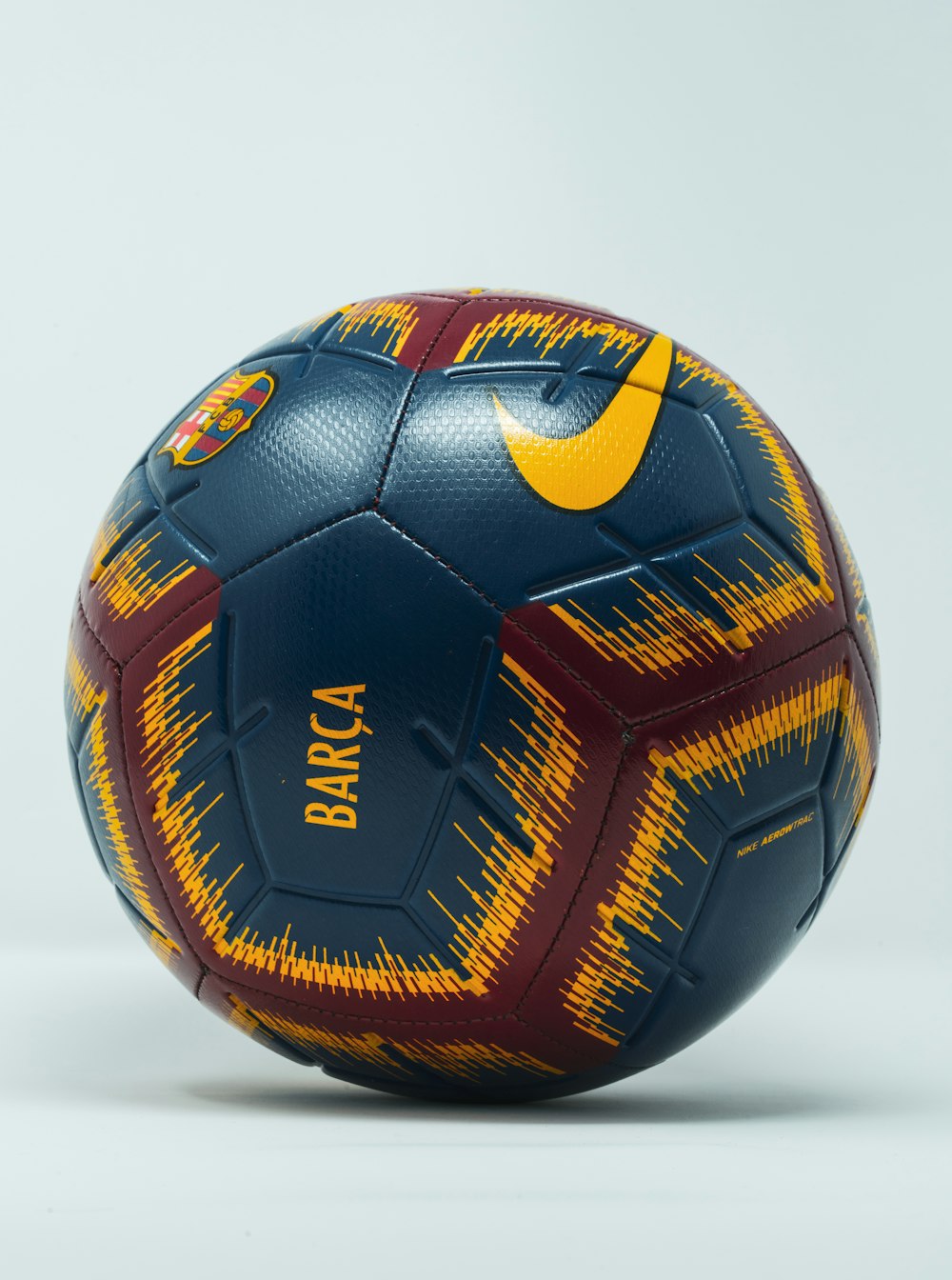 blue, maroon, and yellow Nike soccer ball
