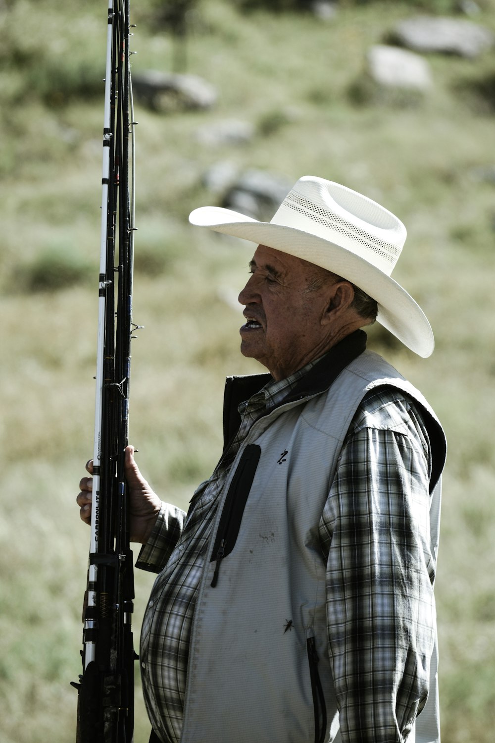 man wearing white vest holding rifle
