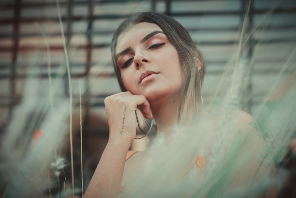 selective focus photography of woman resting head on right hand