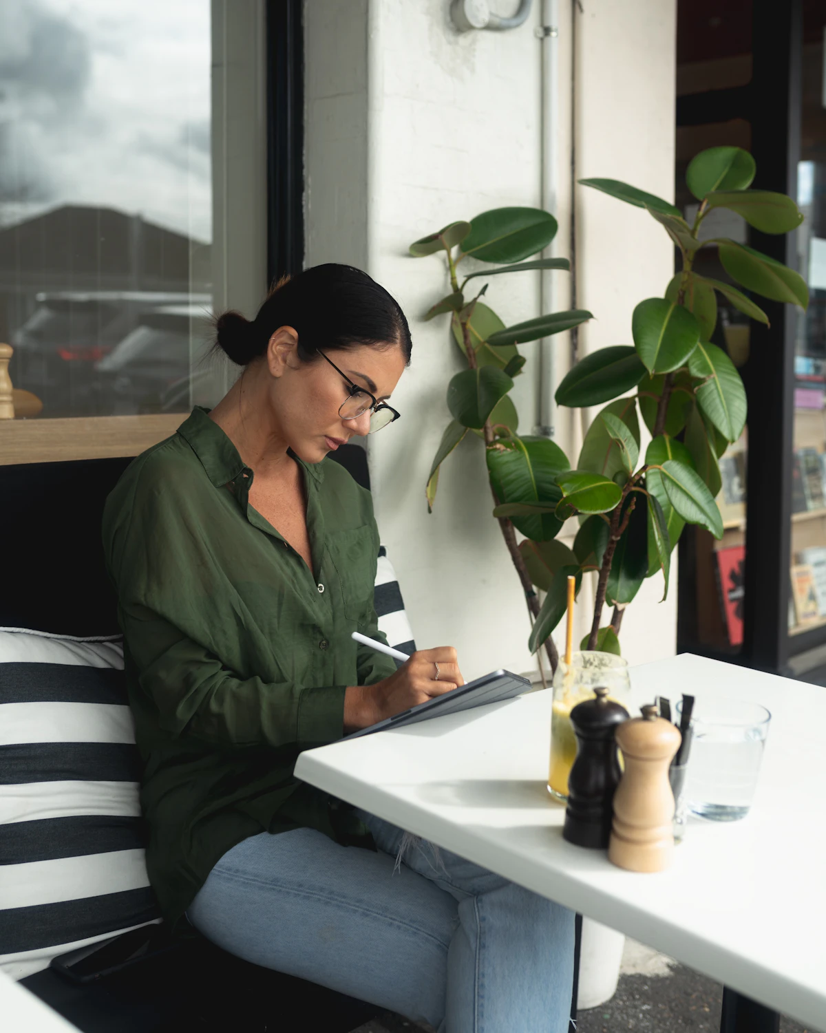 A woman writing thoughtfully at her desk, crafting email stories