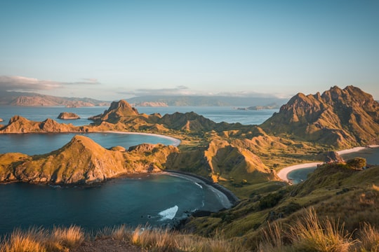brown mountain beside body of water during daytime in Komodo National Park Indonesia