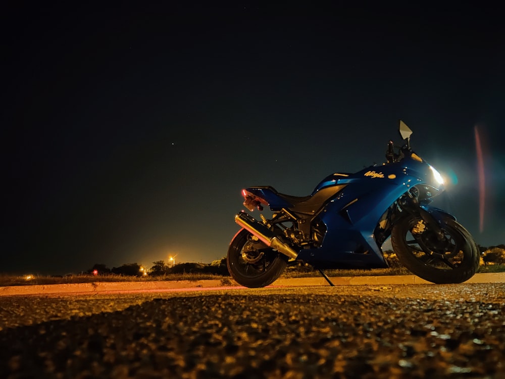 parked blue and black sports bike at night