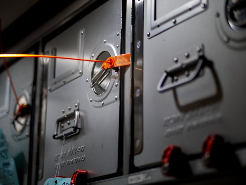 a row of metal lockers with orange handles