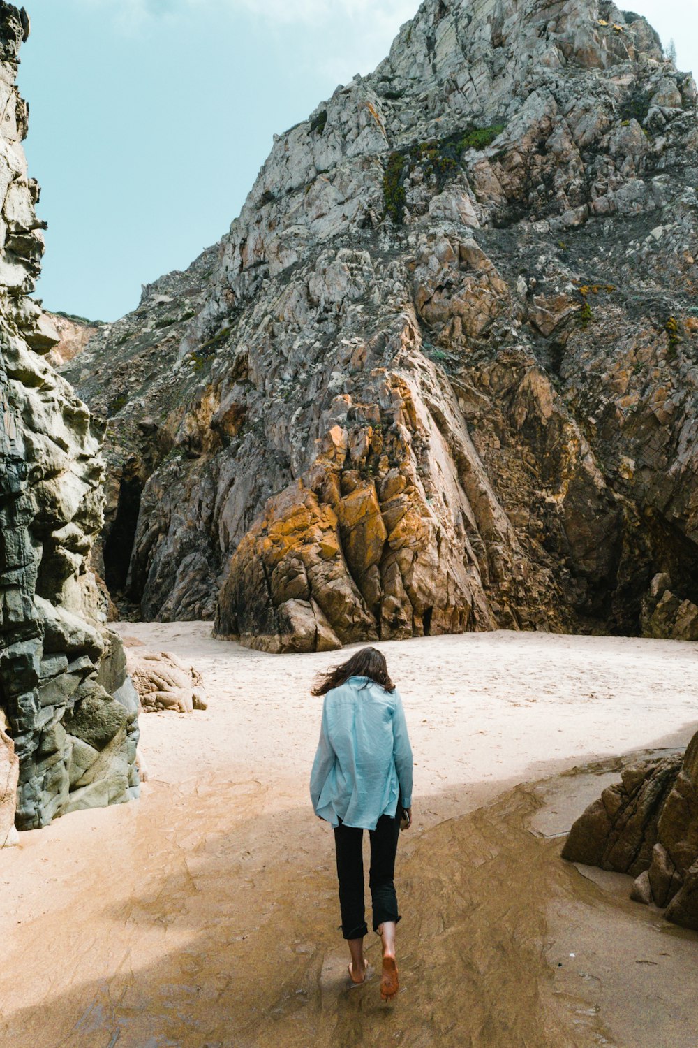 woman standing near huge rocks