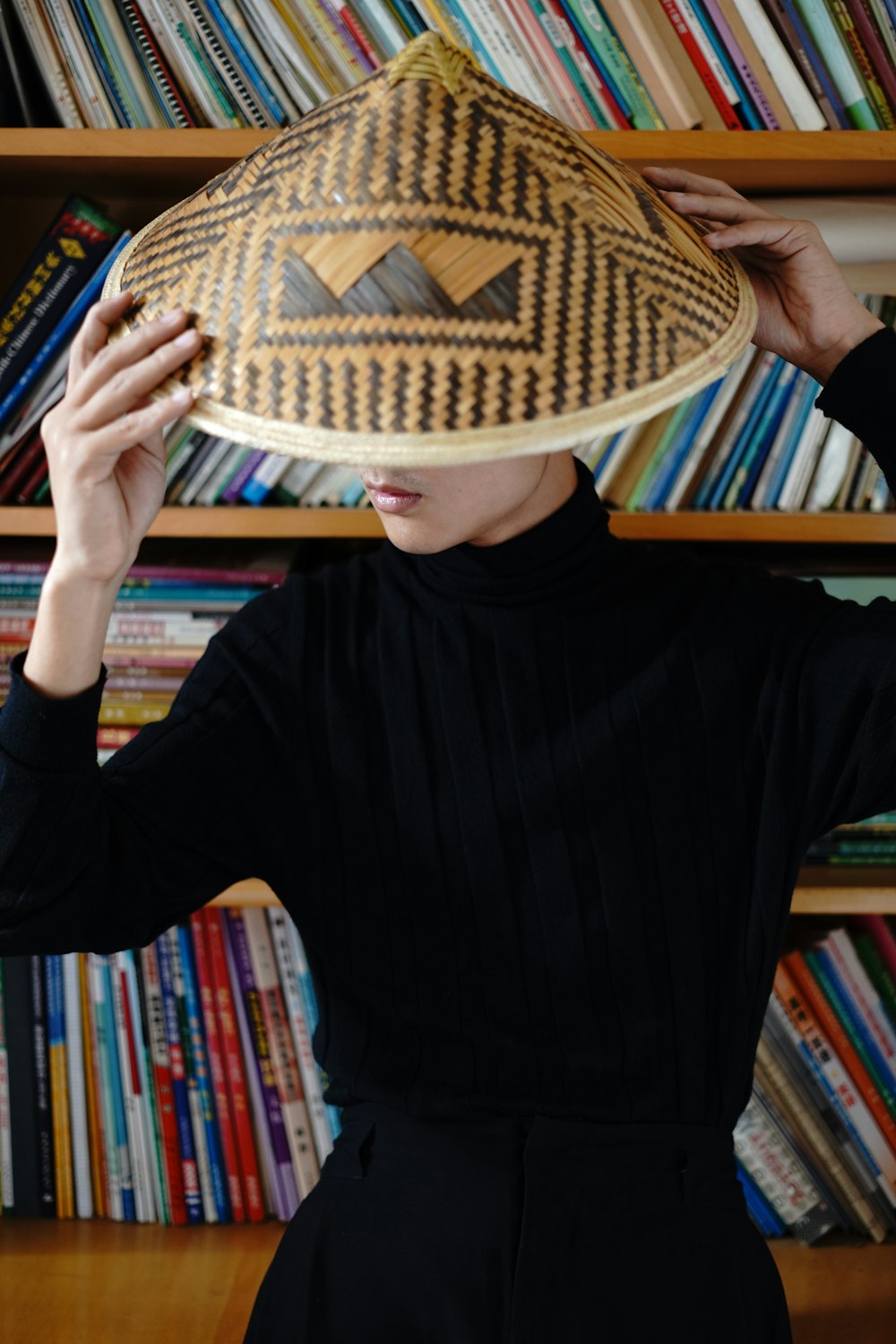 woman wearing black long-sleeved blouse and brown wicker hat