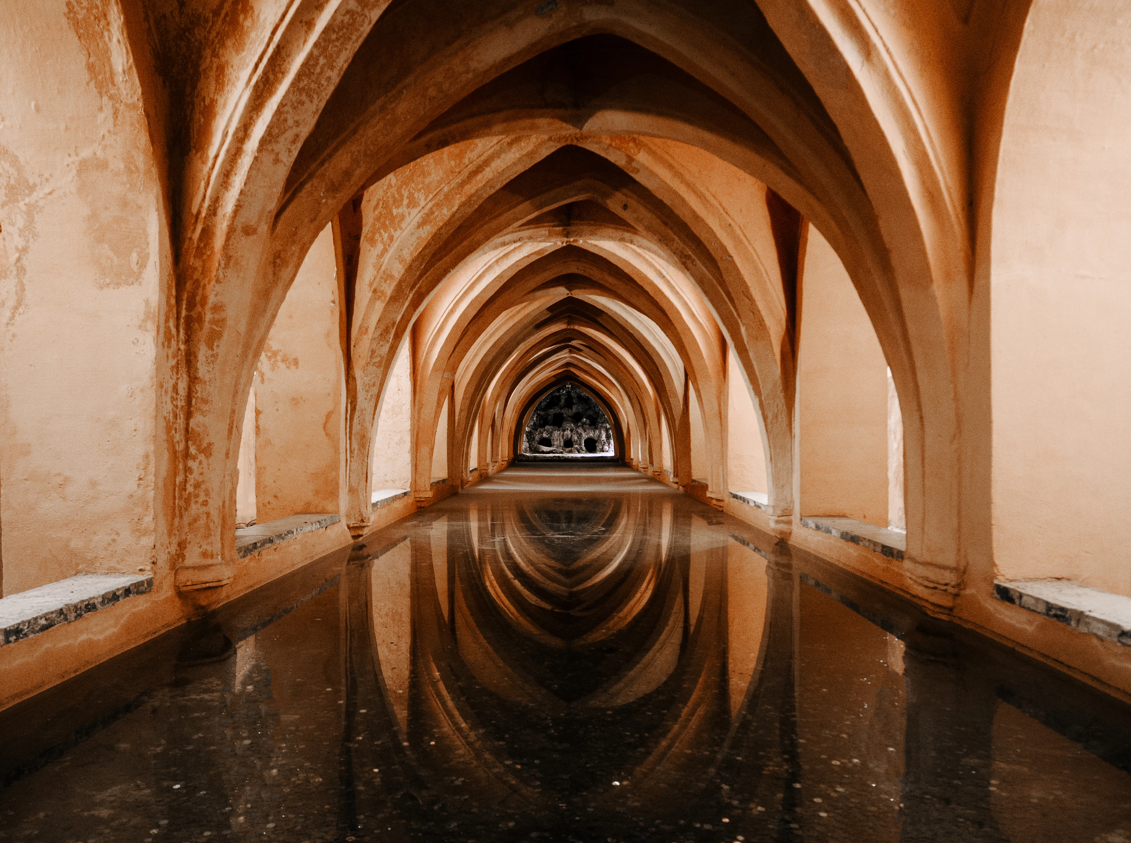 Vaults reflected in still water in the Baths of María de Padilla, Real Alcázar, Seville