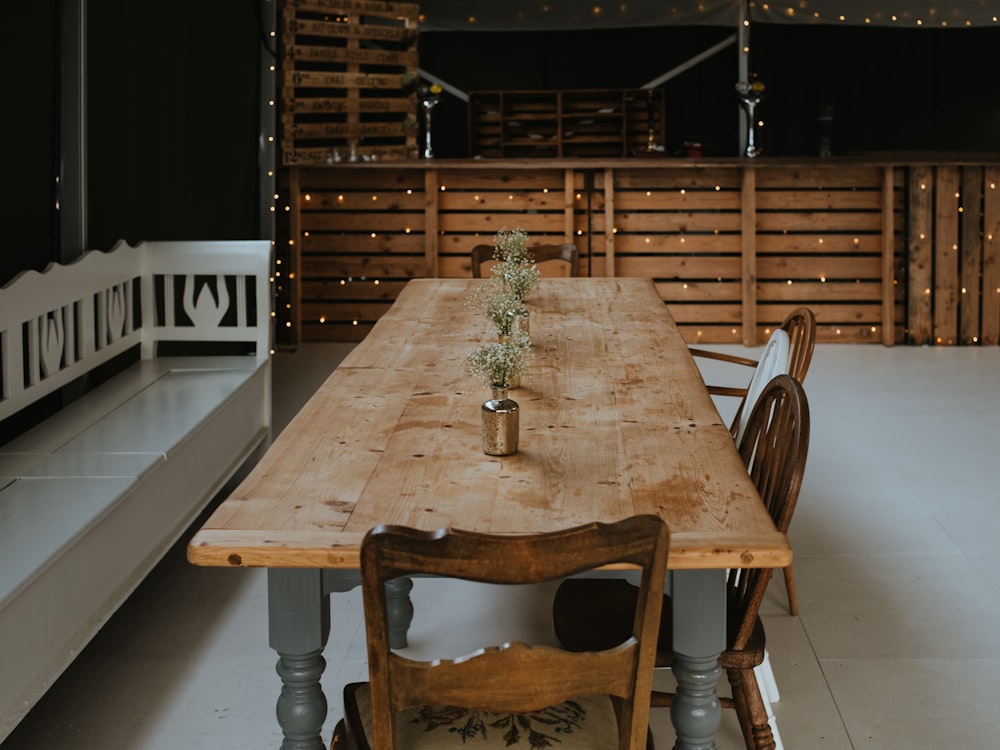 mesa retangular de madeira marrom com quatro cadeiras de jantar