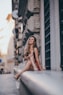 woman sitting near gray concrete wall