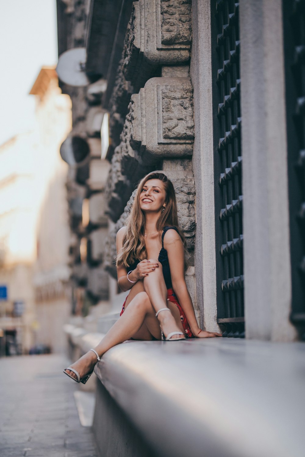 woman sitting near gray concrete wall