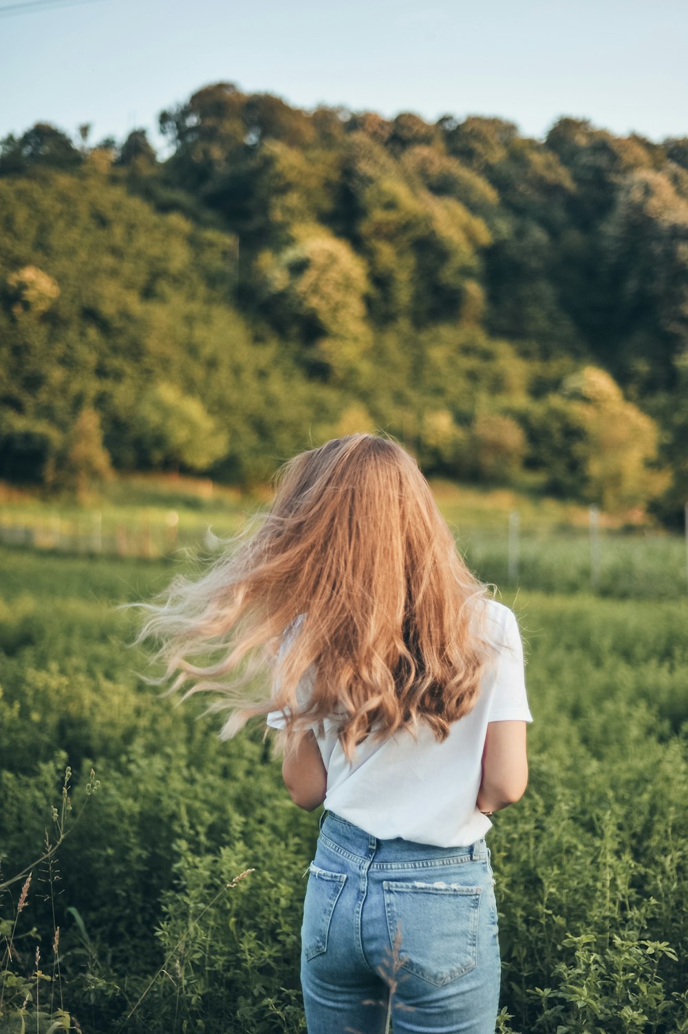 selective focus photo of woman facing grass field