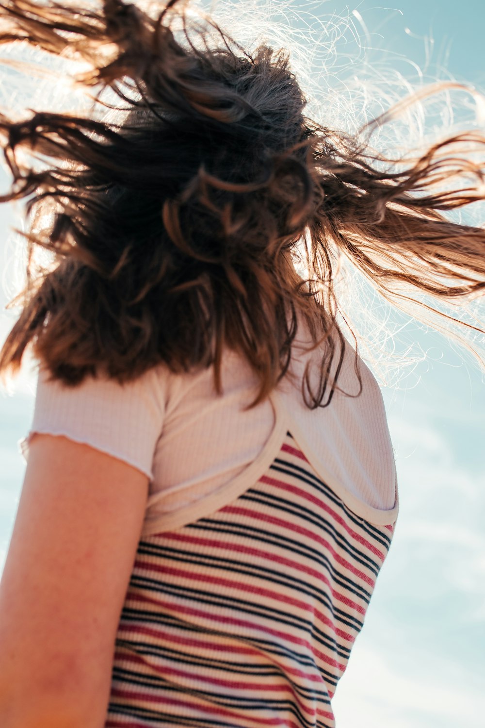 shallow focus photo of person in white, red, and black striped T-shirt