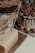 A variety of desserts are displayed on a table. A cake with chocolate drip and Ferrero Rocher toppings is accompanied by a rectangular cake with a fondant finish and decorative flags. In the background, cookies and brownies are arranged on a platter.