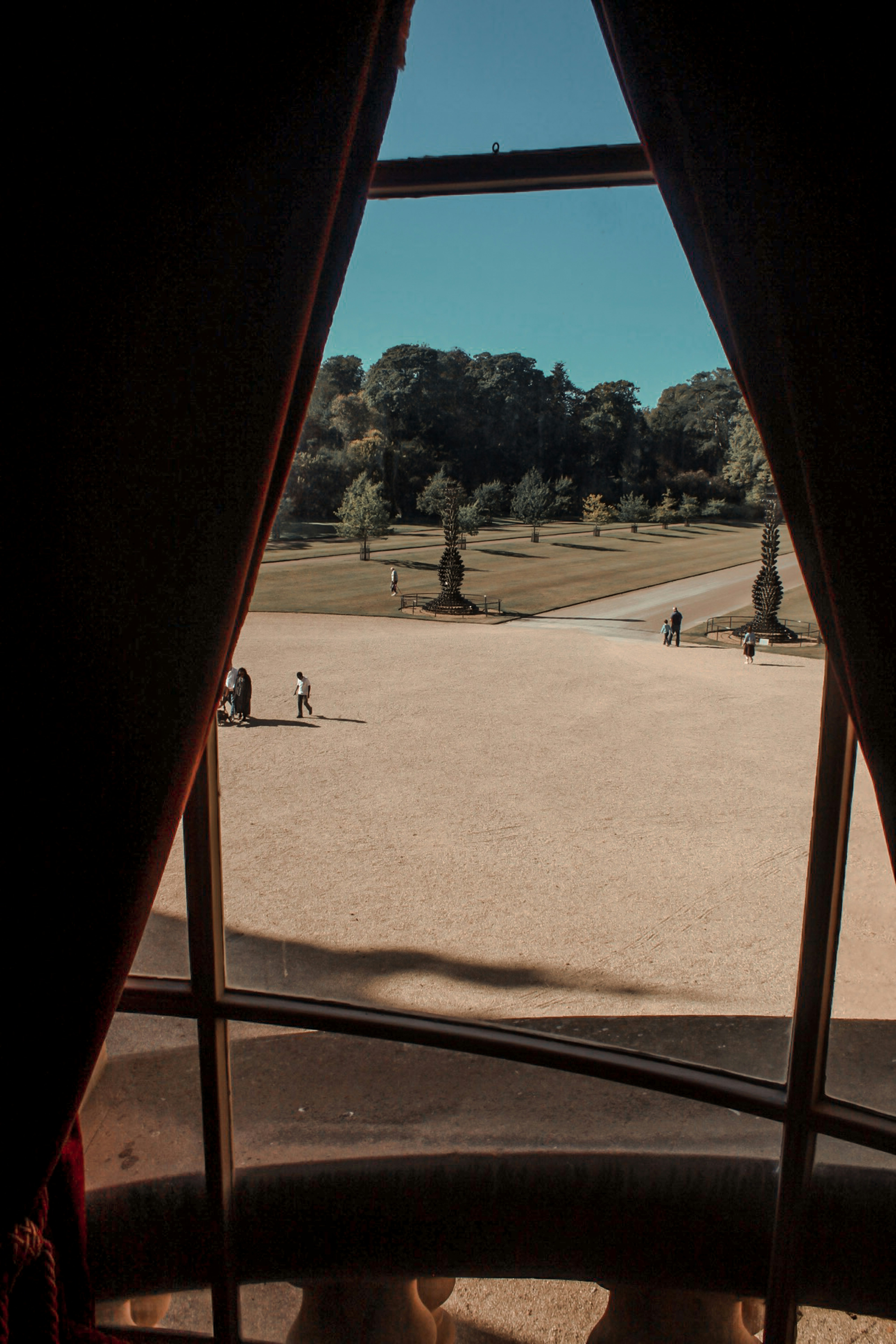 Tagsüber nur wenige Menschen auf dem Feld, umgeben von hohen und grünen Bäumen