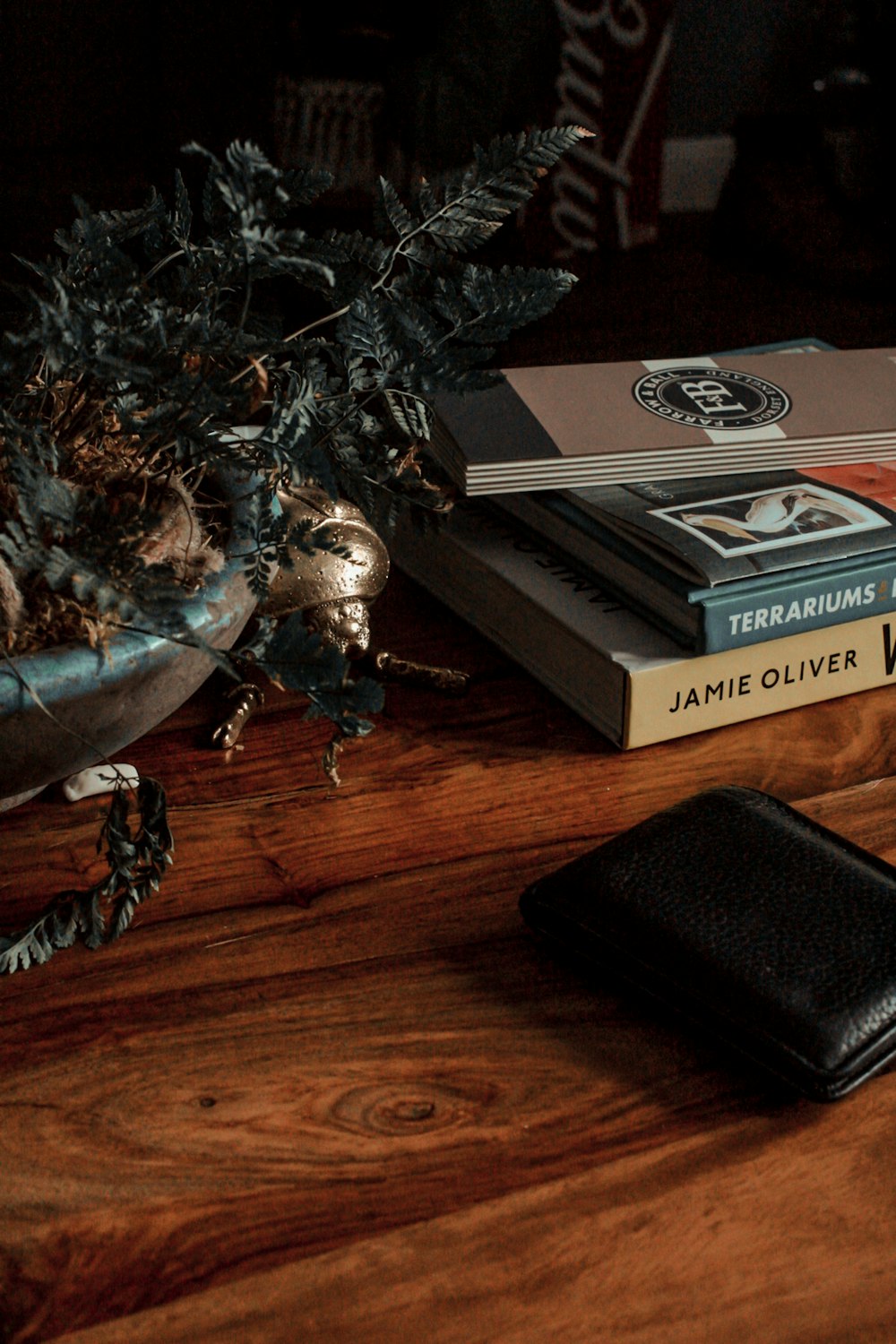 black leather bifold wallet beside pile of books