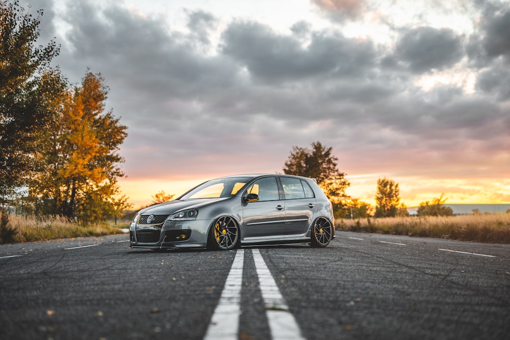 silver 5-door hatchback parked in the middle of the road during day