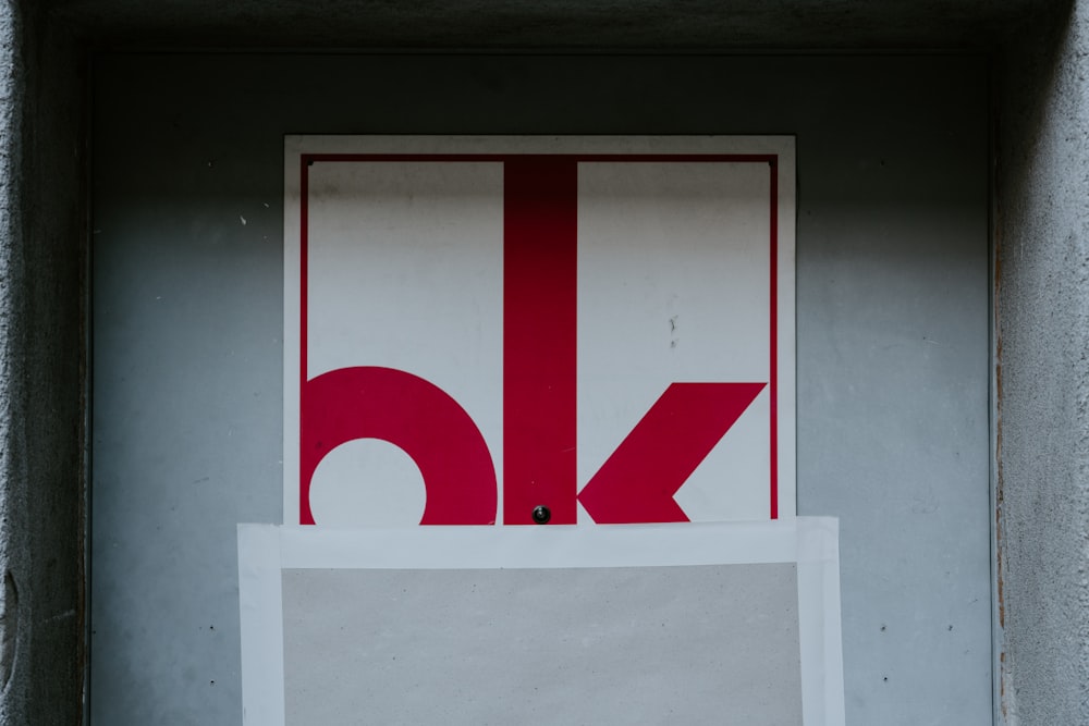 red and white ok label on gray wall