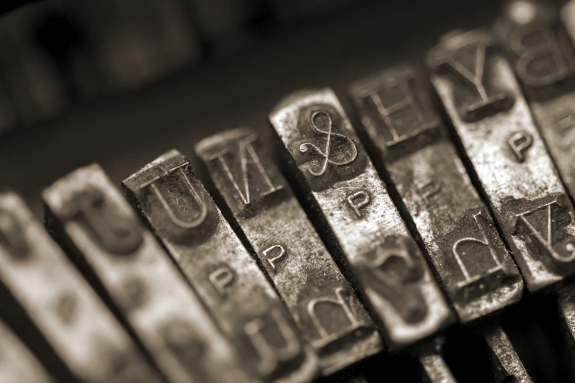 A close-up of a vintage typewriter keyboard with worn keys, symbolizing thoughtful creativity.