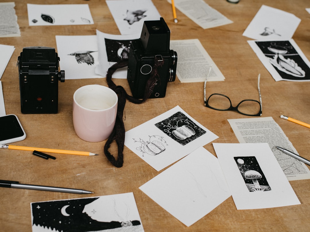 white ceramic mug, pencil and camera