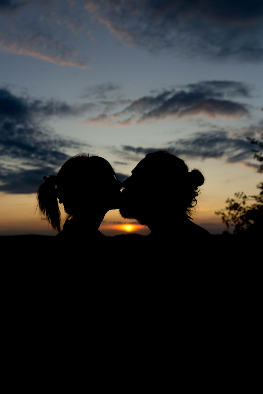 man and woman kissing during golden hour
