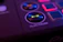 Close-up of a hand clicking a colorful button on a sleek digital interface.