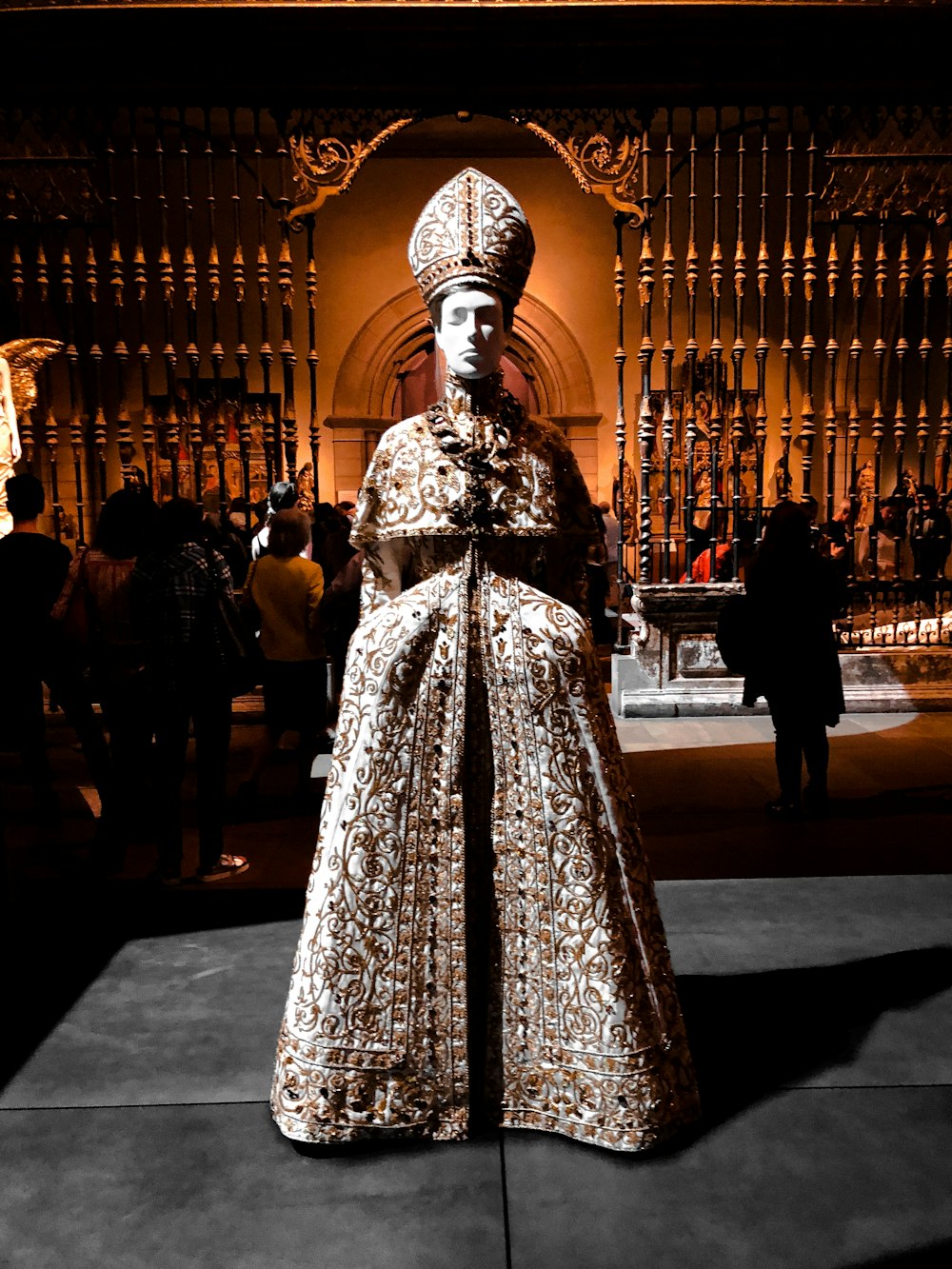 homme portant une robe et un chapeau statue sur une surface grise