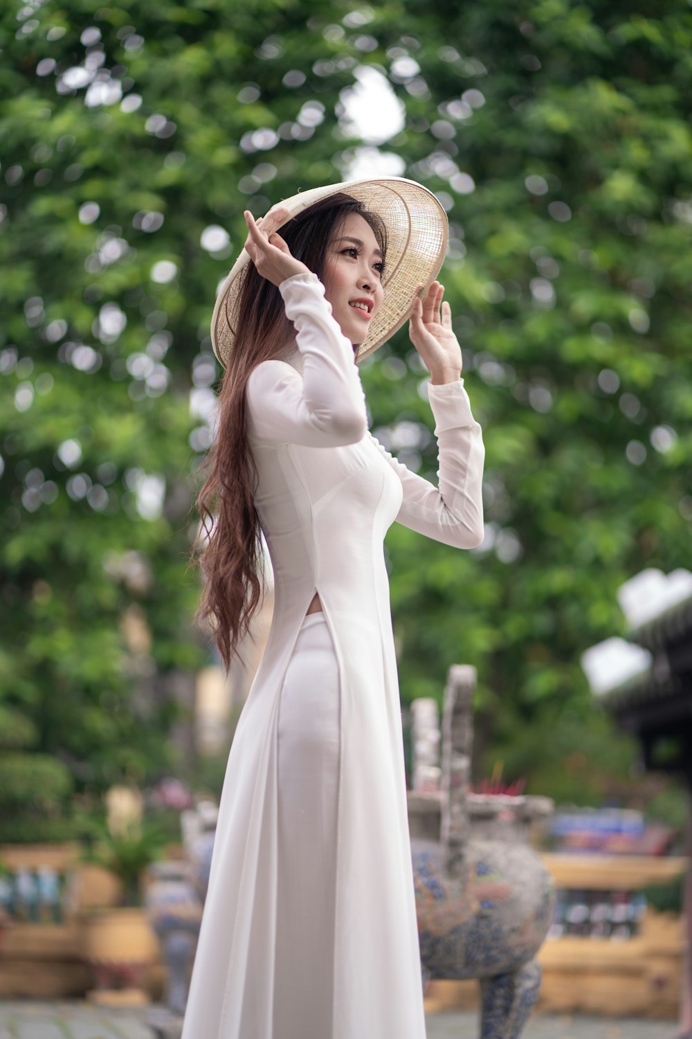 woman wearing white long-sleeved dress and beige sun hat