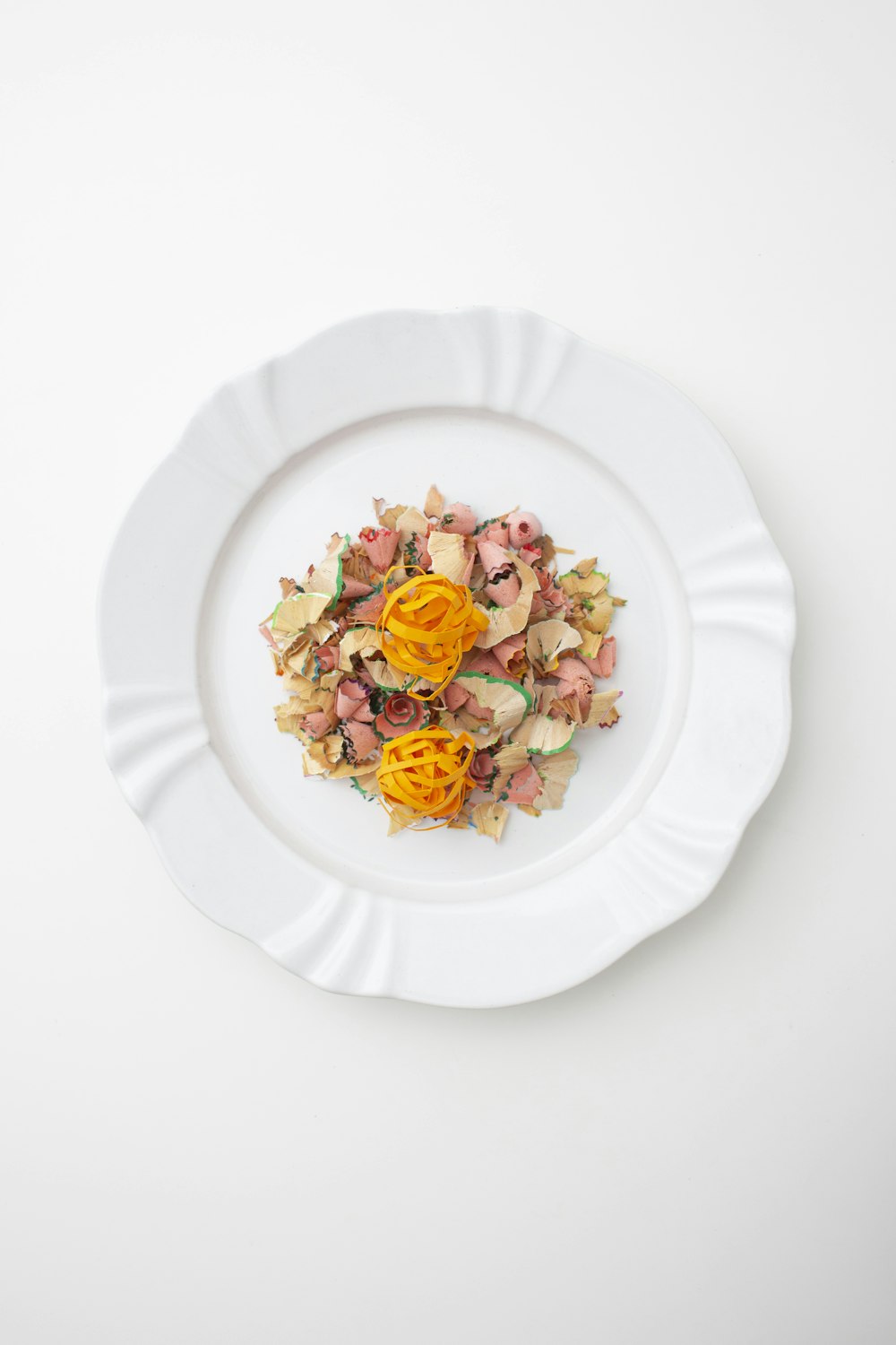 a white plate topped with food on top of a white table