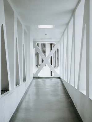 Symmetrical corridor with minimalist design, dark walls, and soft ambient lighting.