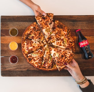 eight sliced pizza with Coca-Cola bottle beside