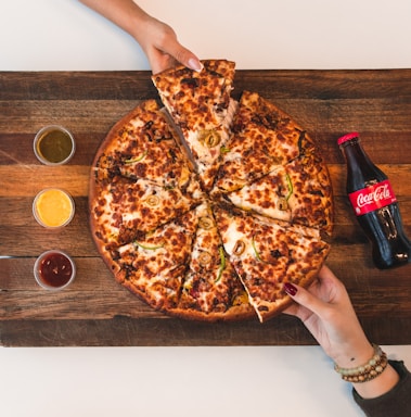 eight sliced pizza with Coca-Cola bottle beside