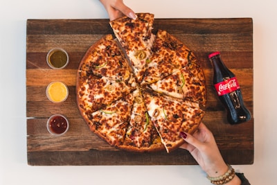 eight sliced pizza with Coca-Cola bottle beside