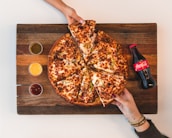 eight sliced pizza with Coca-Cola bottle beside