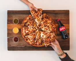 eight sliced pizza with Coca-Cola bottle beside