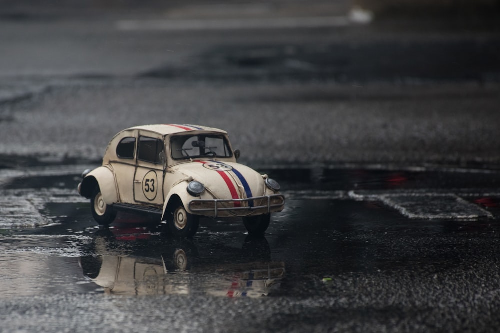 white and red Volkswagen car toy on wet road