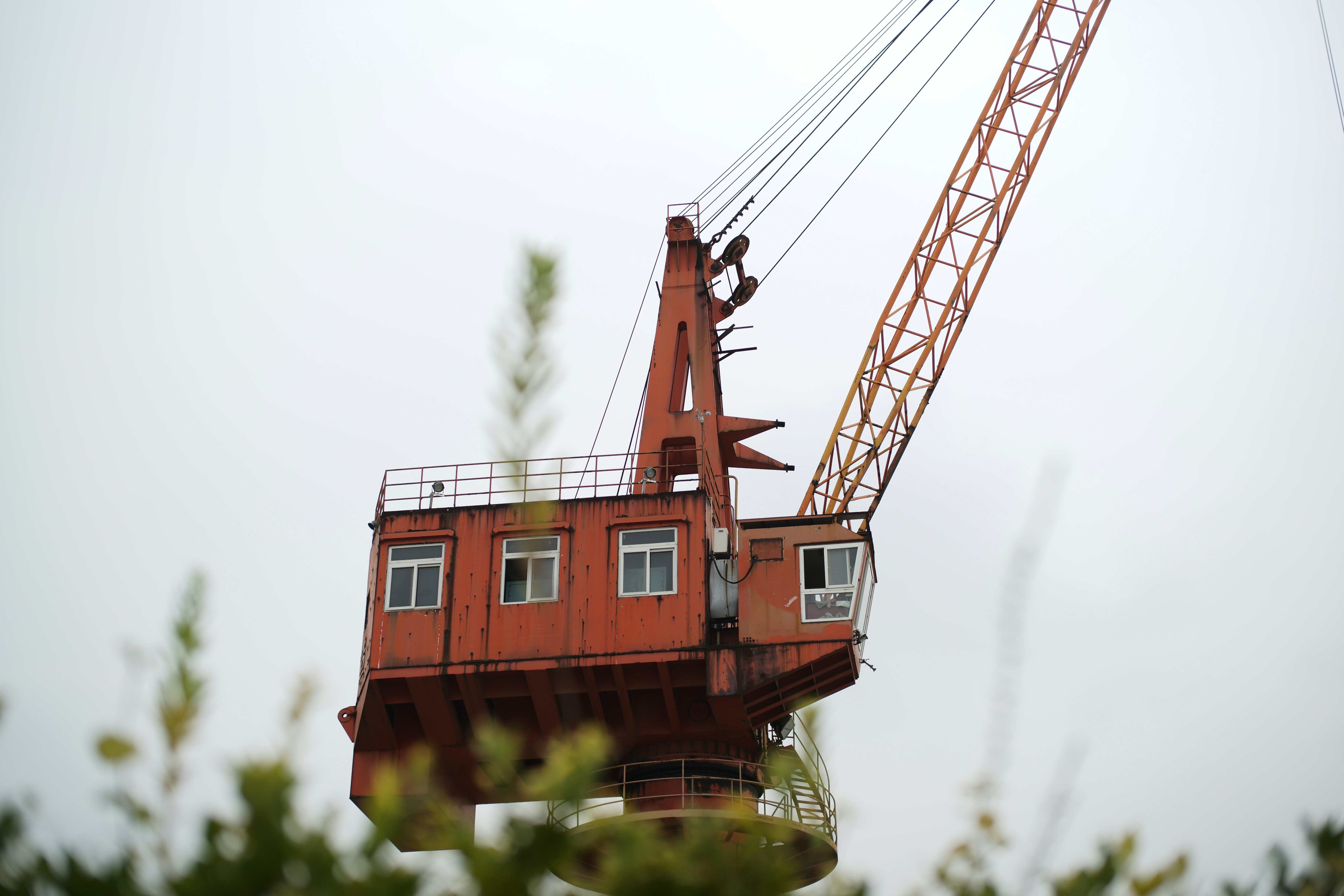 A crane lifting a modular home section into a California backyard