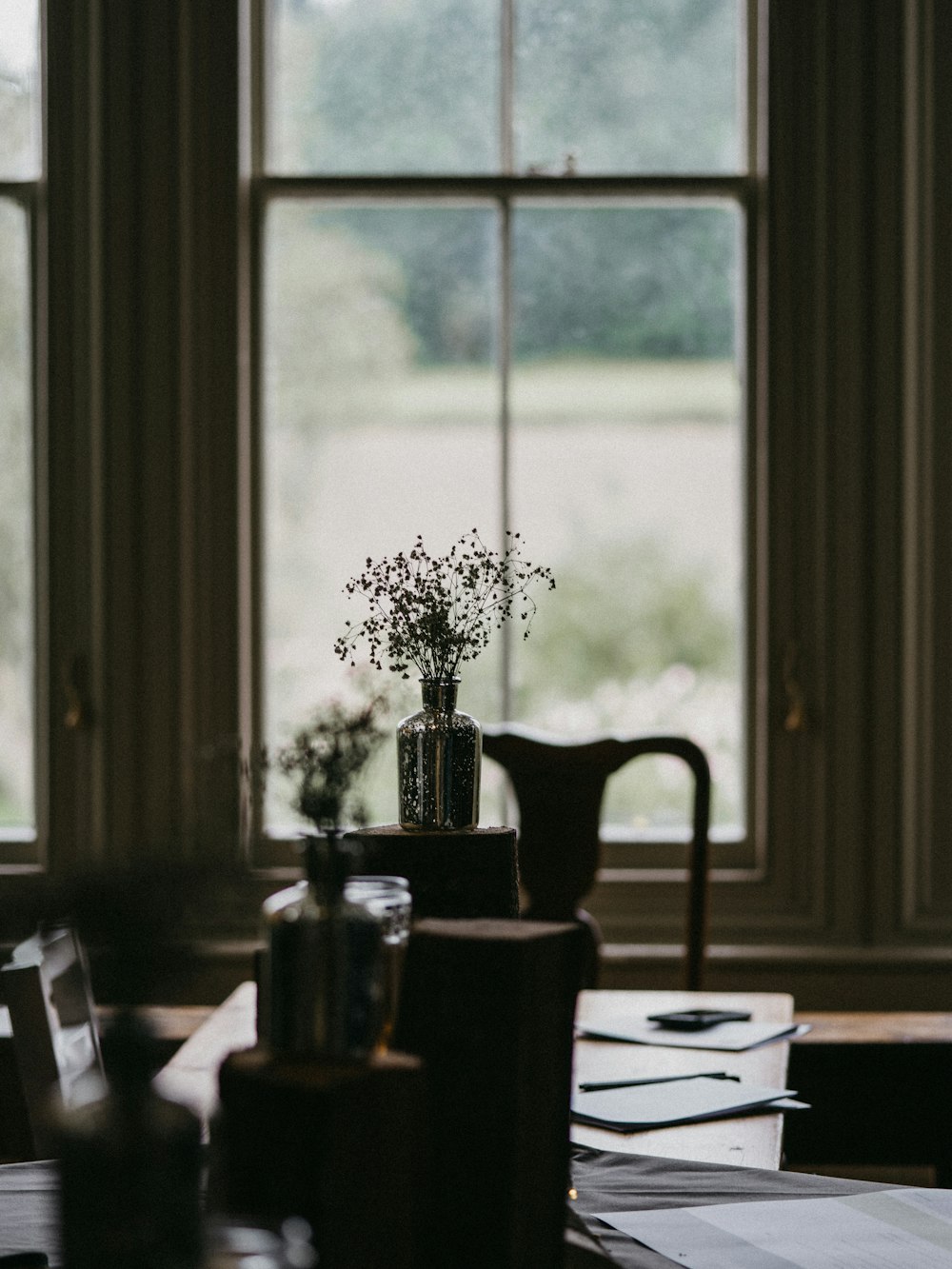 a vase of flowers sitting on a table in front of a window