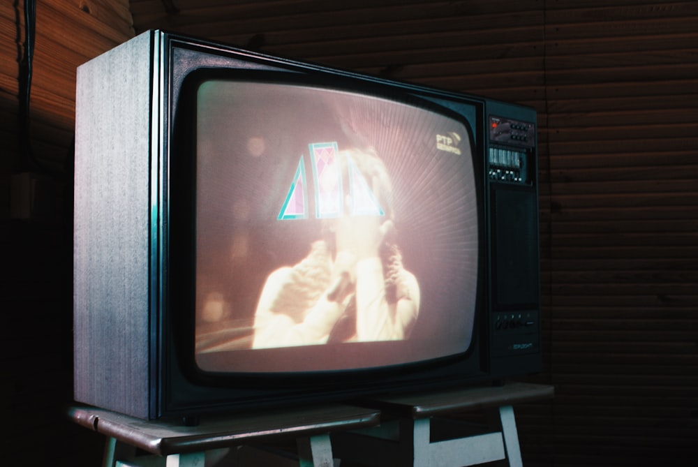 a television sitting on top of a step ladder