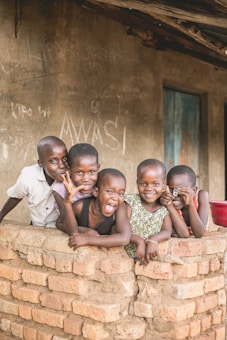 five boys beside brick wall