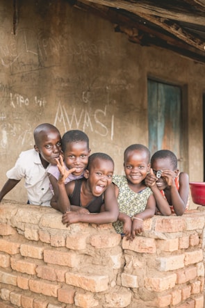 five boys beside brick wall