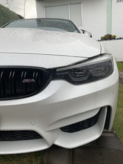 Wide angle of a sleek white car parked on a driveway, fully detailed and spotless